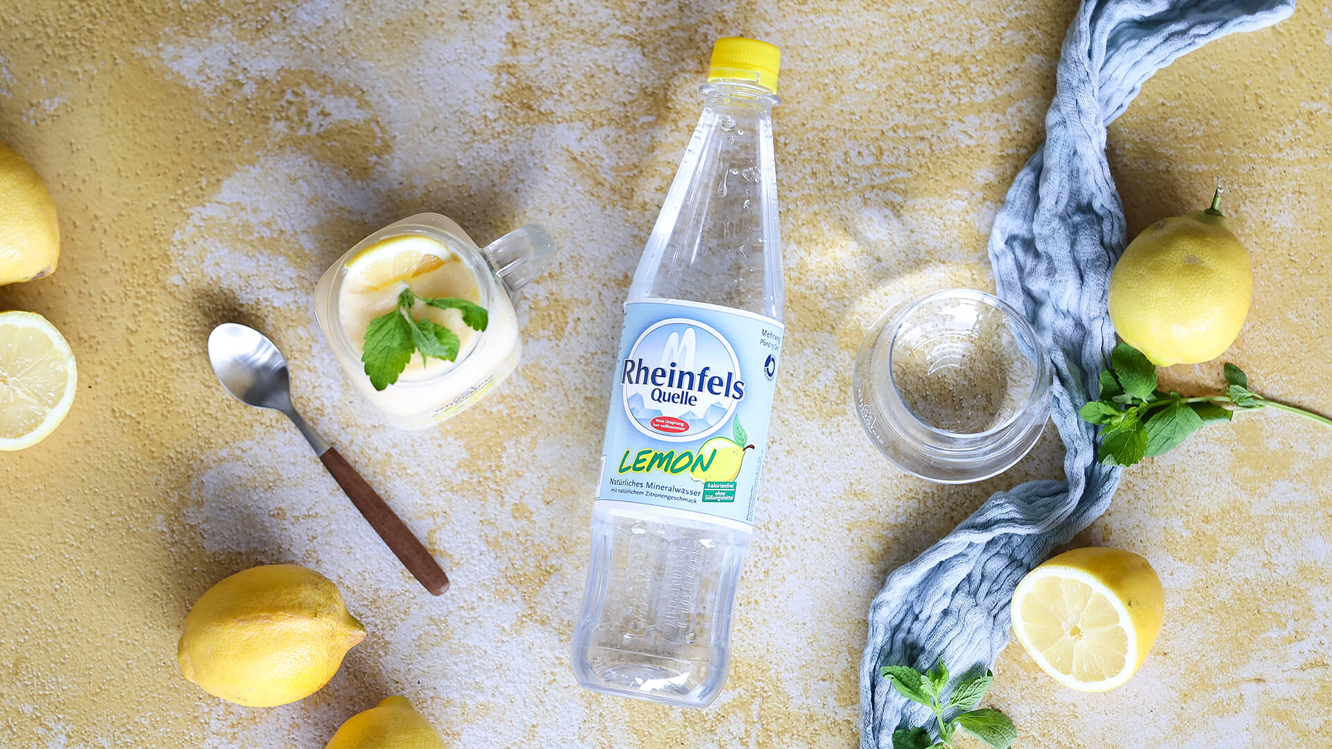 Zitronen-Schichtcreme im Glas mit Rheinfels Quelle Lemon Flasche