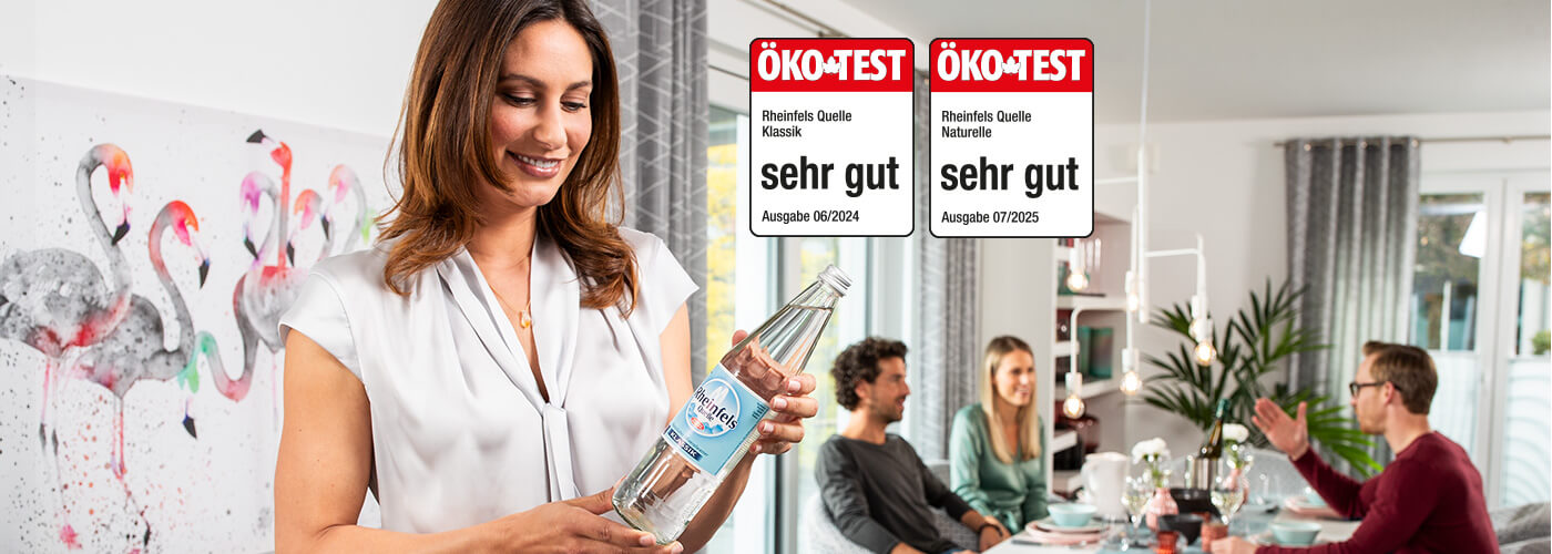 Frau hält Rheinfels Klassik Flasche in der Hand. Daneben ein Ökotest Siegel mit der Note sehr gut